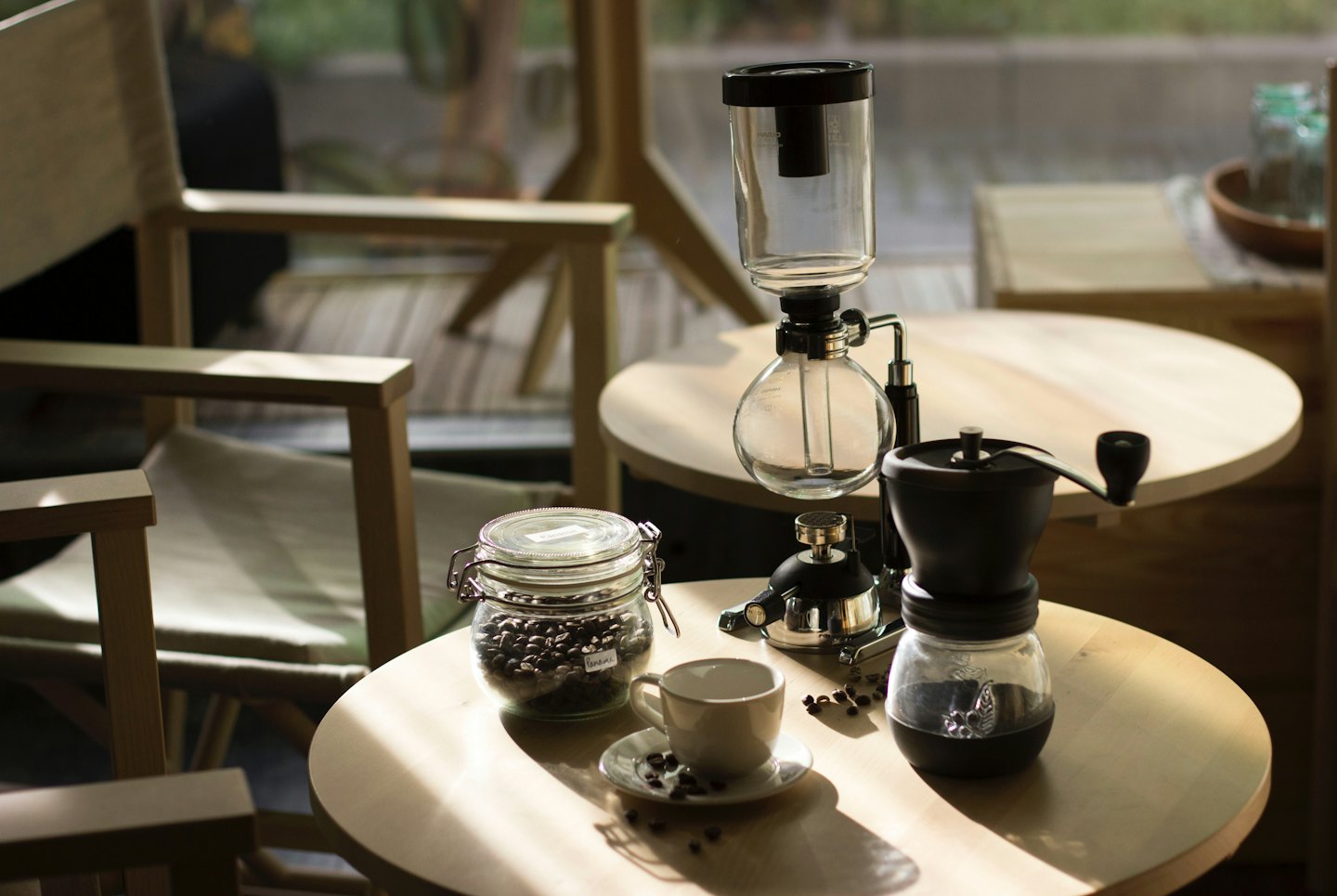 Ahşap kafe masasında sergilenen kahve demleme ekipmanları.
