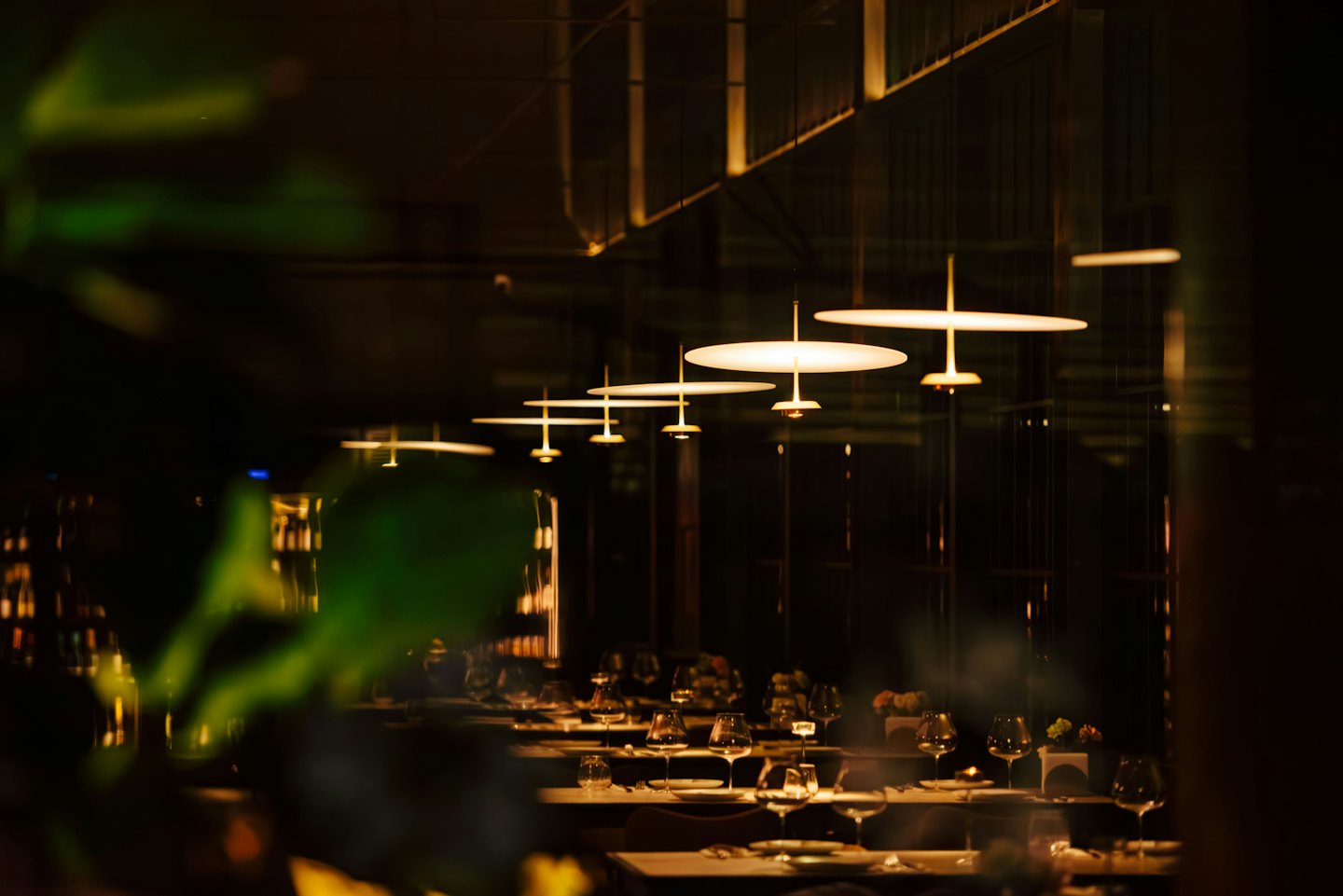 Disk ışıklı, masaları kurulmuş modern restoran salonu.