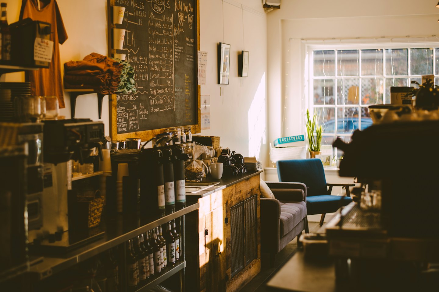Menü panosu ve oturma alanı bulunan bir kafe tezgahı.